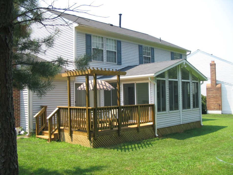The back exterior of an Oak Island home, featuring a new deck with a pergola.